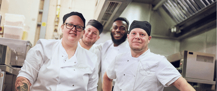 Kitchen assistant organising metal containers